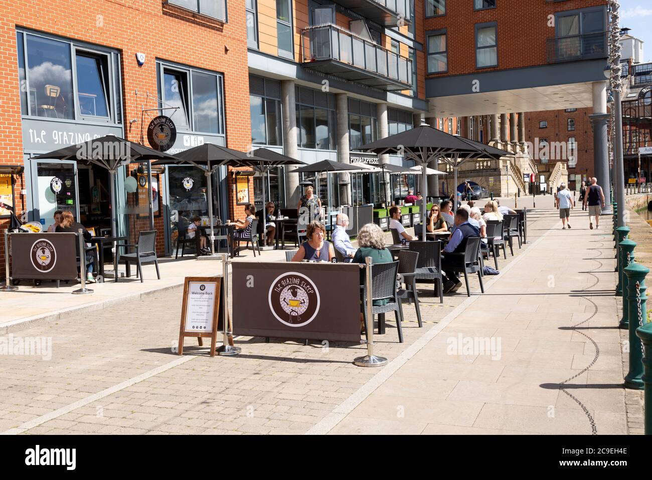 People sitting outside newly reopened cafes on the waterfront, Wet Dock, Ipswich, Suffolk, England, UK July 2020 Stock Photo