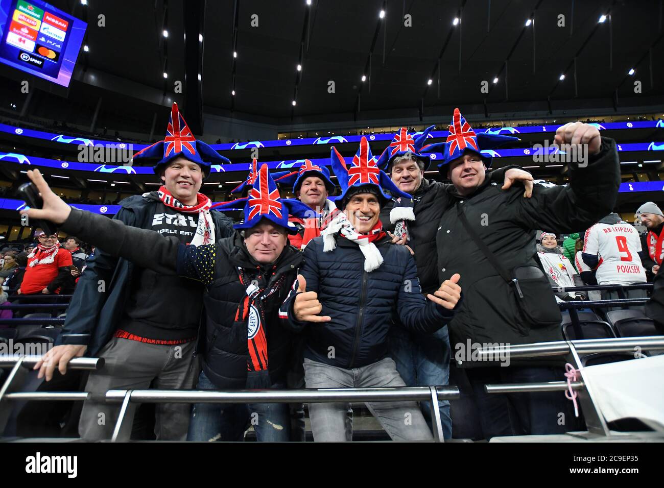 LONDON, ENGLAND - FEBRUARY 19, 2020: German fans celebrate Brexit wearing Union Jack hats ahead of the first leg of the 2019/20 UEFA Champions League Round of 16 game between Tottenham Hotspur FC and RB Leipzig at Tottenham Hotspur Stadium. Stock Photo