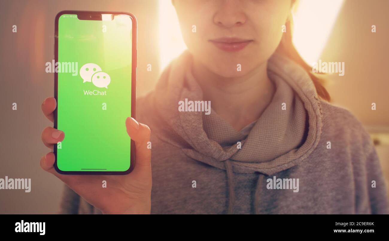 KYIV, UKRAINE-JANUARY, 2020: Wechat on Smartphone Screen. Young Girl Showing Smart Phone Screen with Wechat on it while Looking at the Camera. Focus on Smartphone. Stock Photo