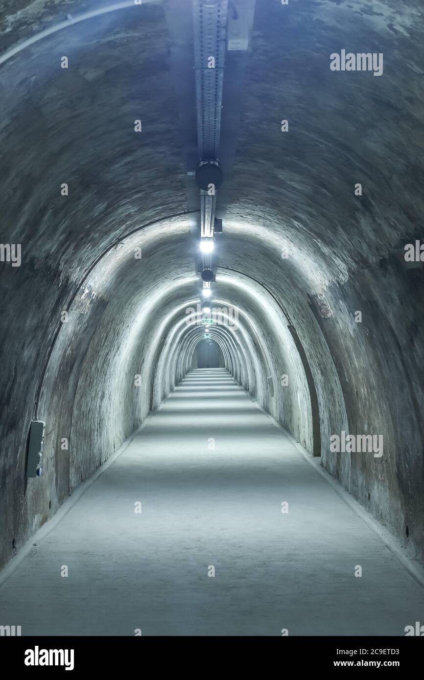 Old concrete tunnel with fluorescent lights. Stock Photo
