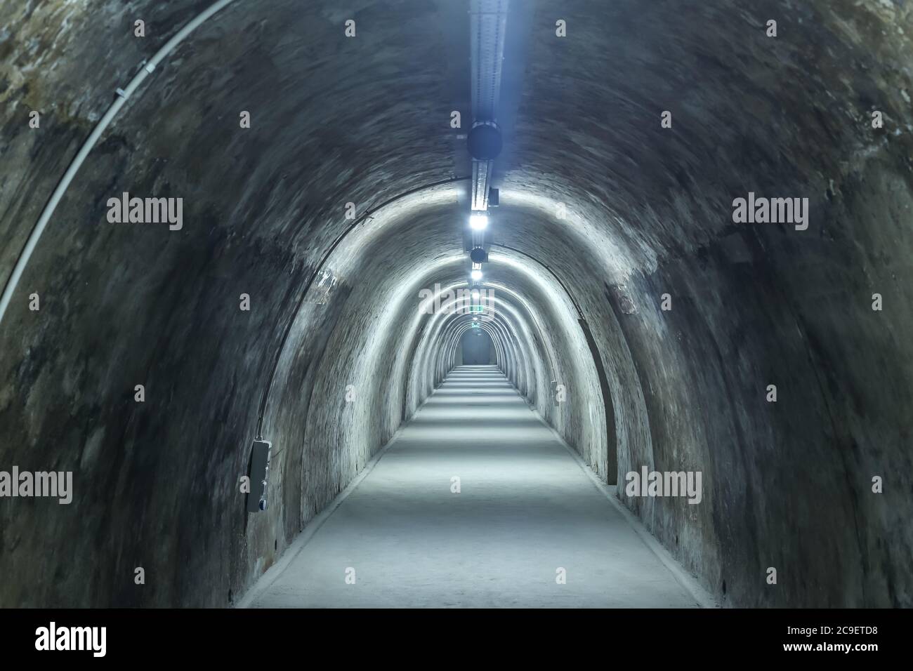 Old concrete tunnel with fluorescent lights. Stock Photo