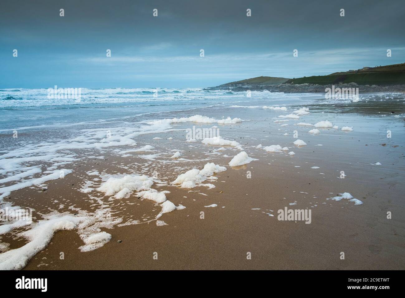 Spume or Sea foam driven on to the beach by strong windy conditiopns at Fistral in Newquay in Cornwall UK. Stock Photo