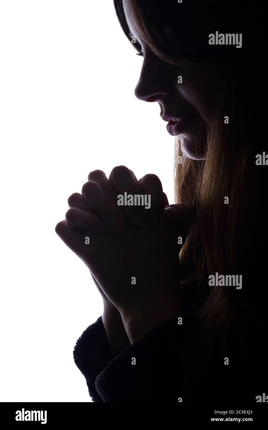 Young woman looking down, hope and request - silhouette of a side view Stock Photo
