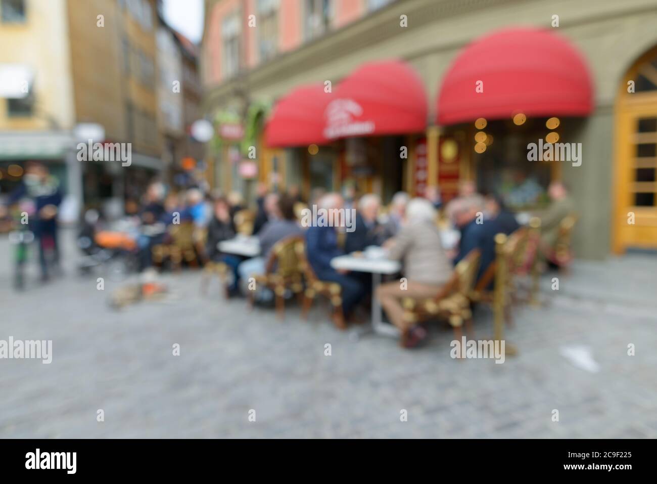 Blurred tables and chairs with people chatting outside the restaurant Stock Photo
