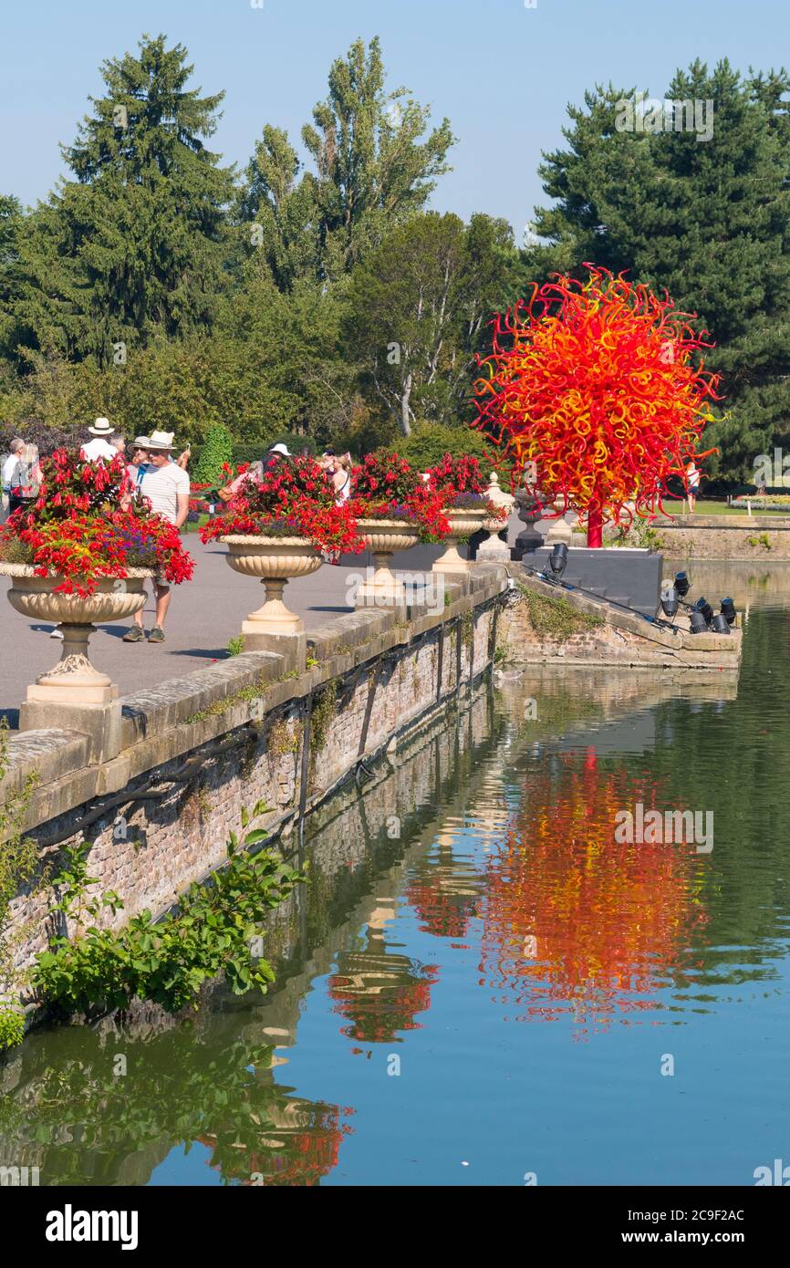 Kew Royal Botanical Gardens iconic Dale Chihuly Reflections Exhibition colourful glass sculptures sculpture art Summer Sun lake people reflection Stock Photo