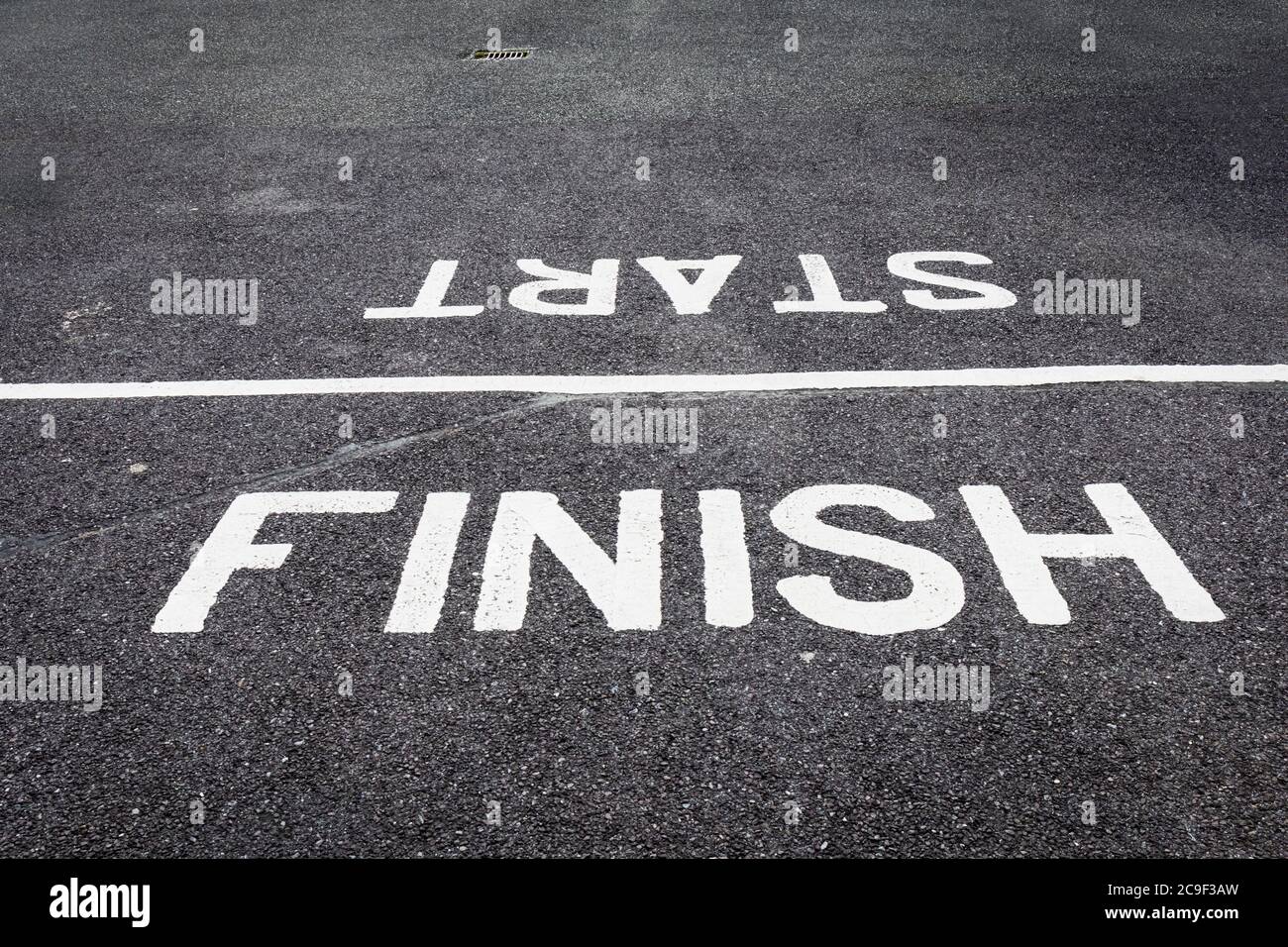 Start and finish line painted on road. Stock Photo