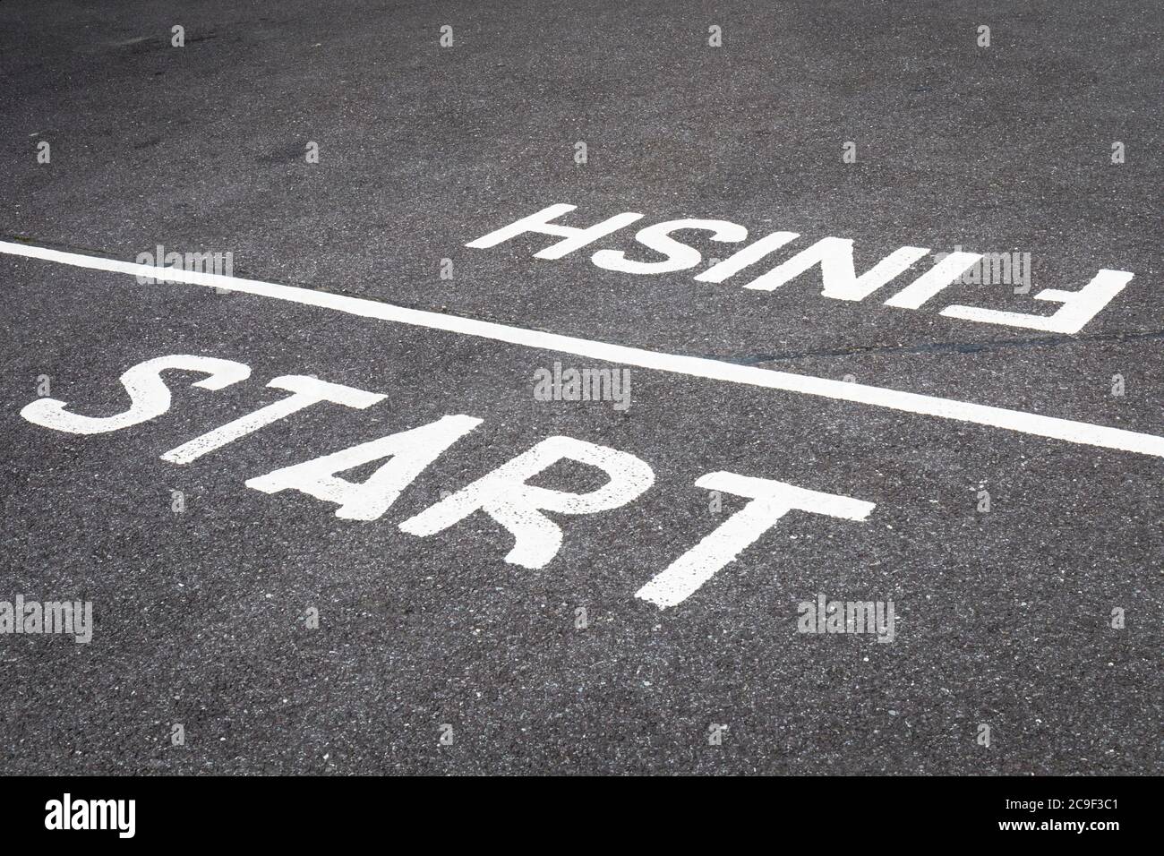 Start and finish line painted on road. Stock Photo