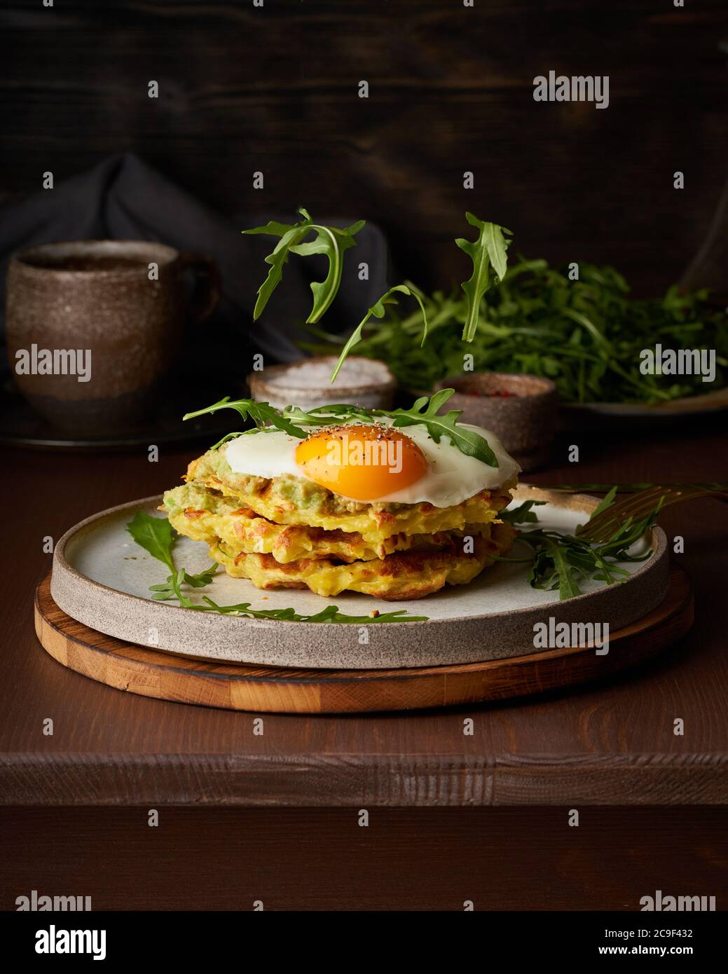 Homemade keto waffles with fried egg, flying arugula, mozzarella cheese