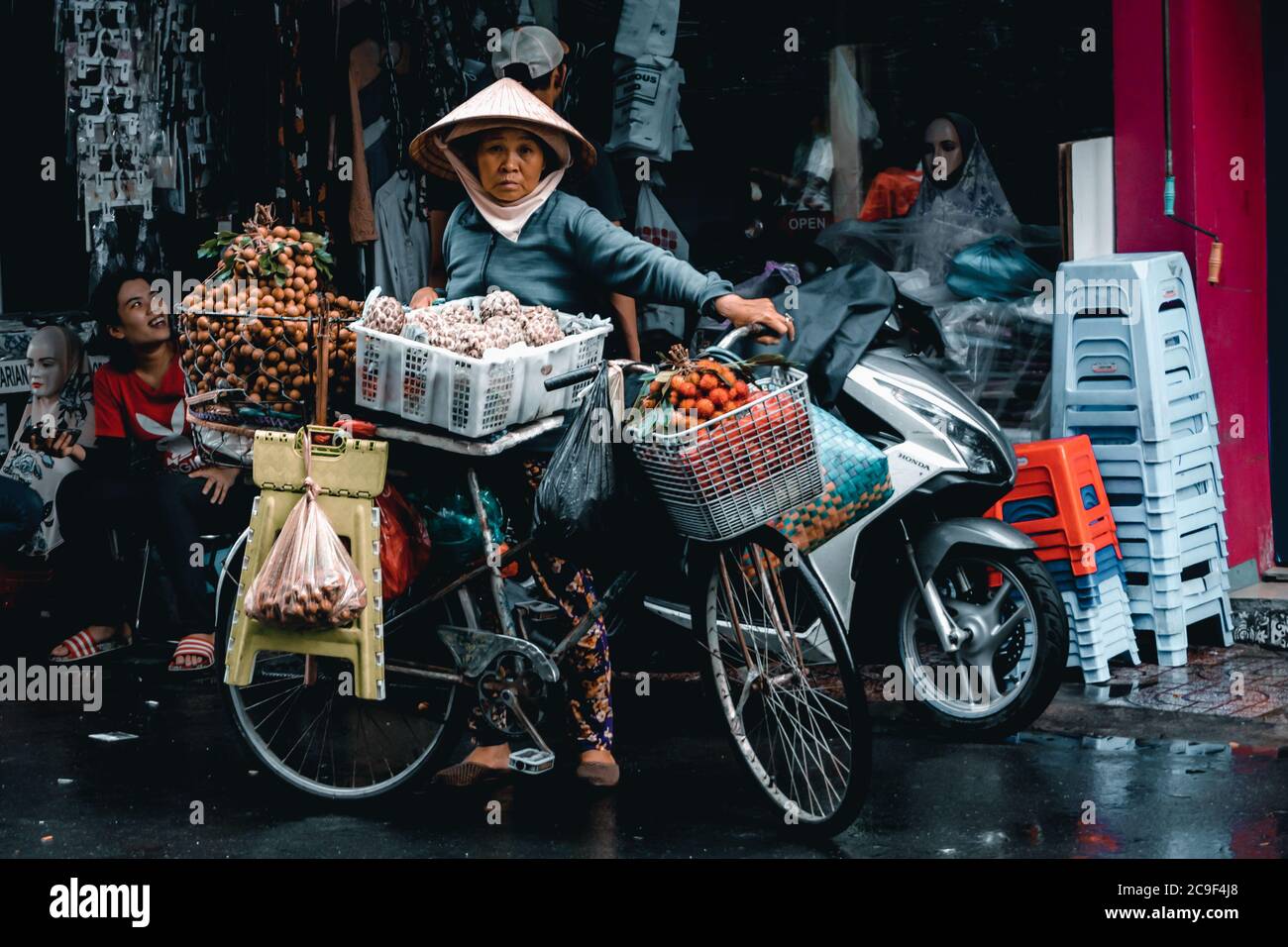 Vietnamese woman selling fruits in her bike on the streets of Ho Chi Minh, Vietnam. Stock Photo