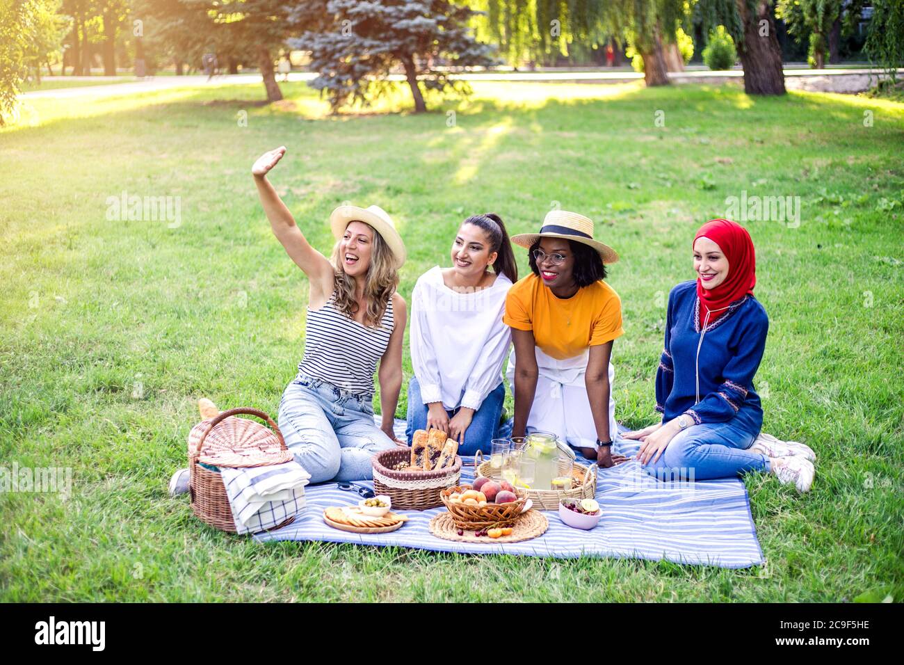Young multiracial women are on picnic in the park. Stock Photo