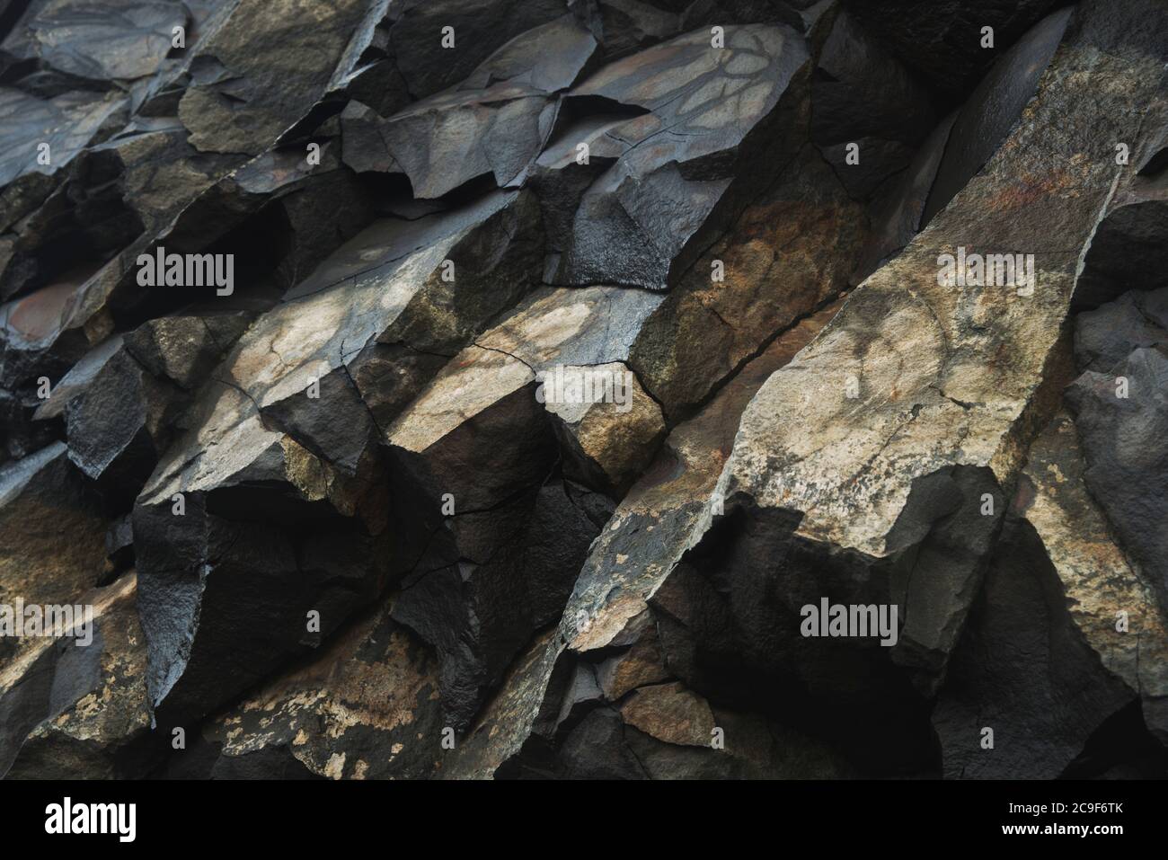 https://c8.alamy.com/comp/2C9F6TK/close-up-of-a-yellow-and-black-rock-formation-at-the-base-of-a-cliff-sharp-detail-and-texture-throughout-2C9F6TK.jpg