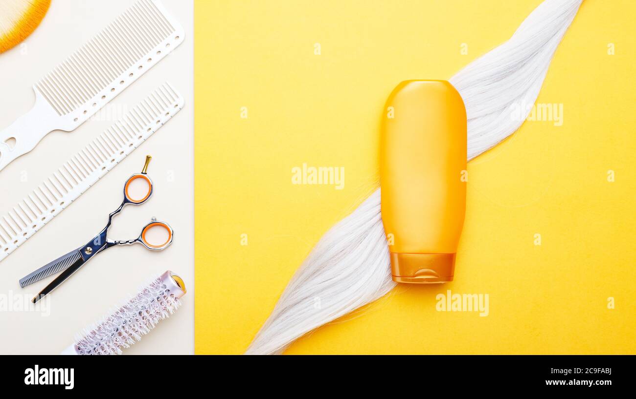 Gold shampoo bottle mock up on lock of blonde dyed hair strand on