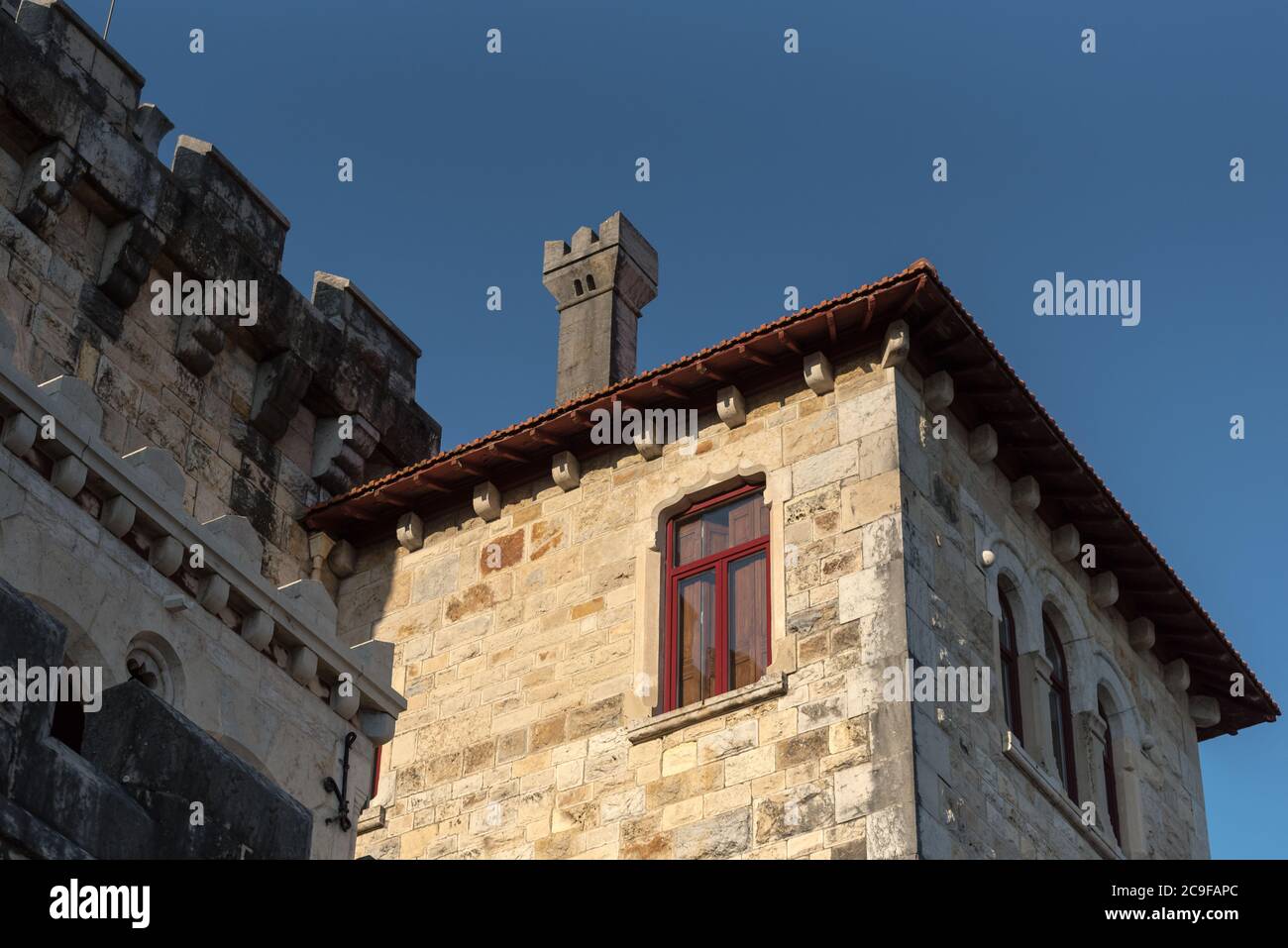 Architectural detail of faux castle mansion house building of stone blocks by the seaside on boardwalk in Estoril, Portugal Stock Photo