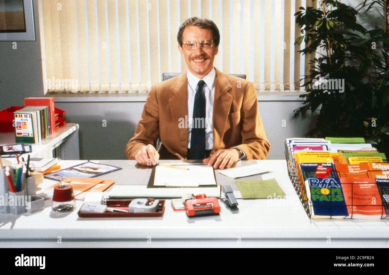 Gernot Endemann als Versicherungsvertreter seriös mit Anzug und Krawatte am Schreibtisch in der ZDF-Sendung 'Rente aber sicher', Deutschland 1990. Stock Photo