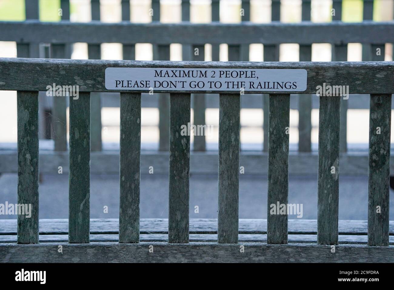 ocial distancing notice on a bench during day four of the Goodwood Festival at Goodwood Racecourse, Chichester. Stock Photo