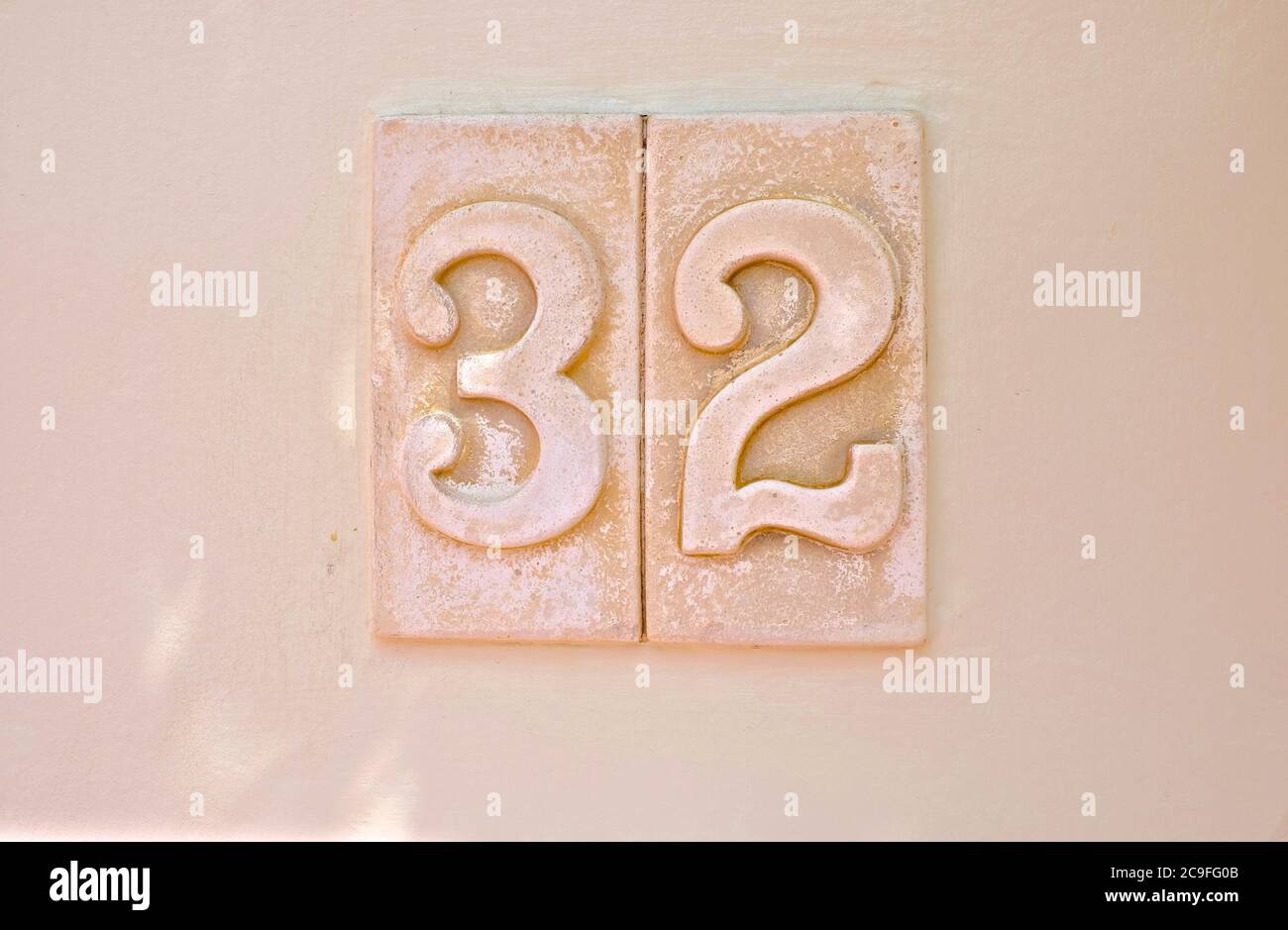 32, number thirty-two, light tone digits on pale background surface. Stock Photo
