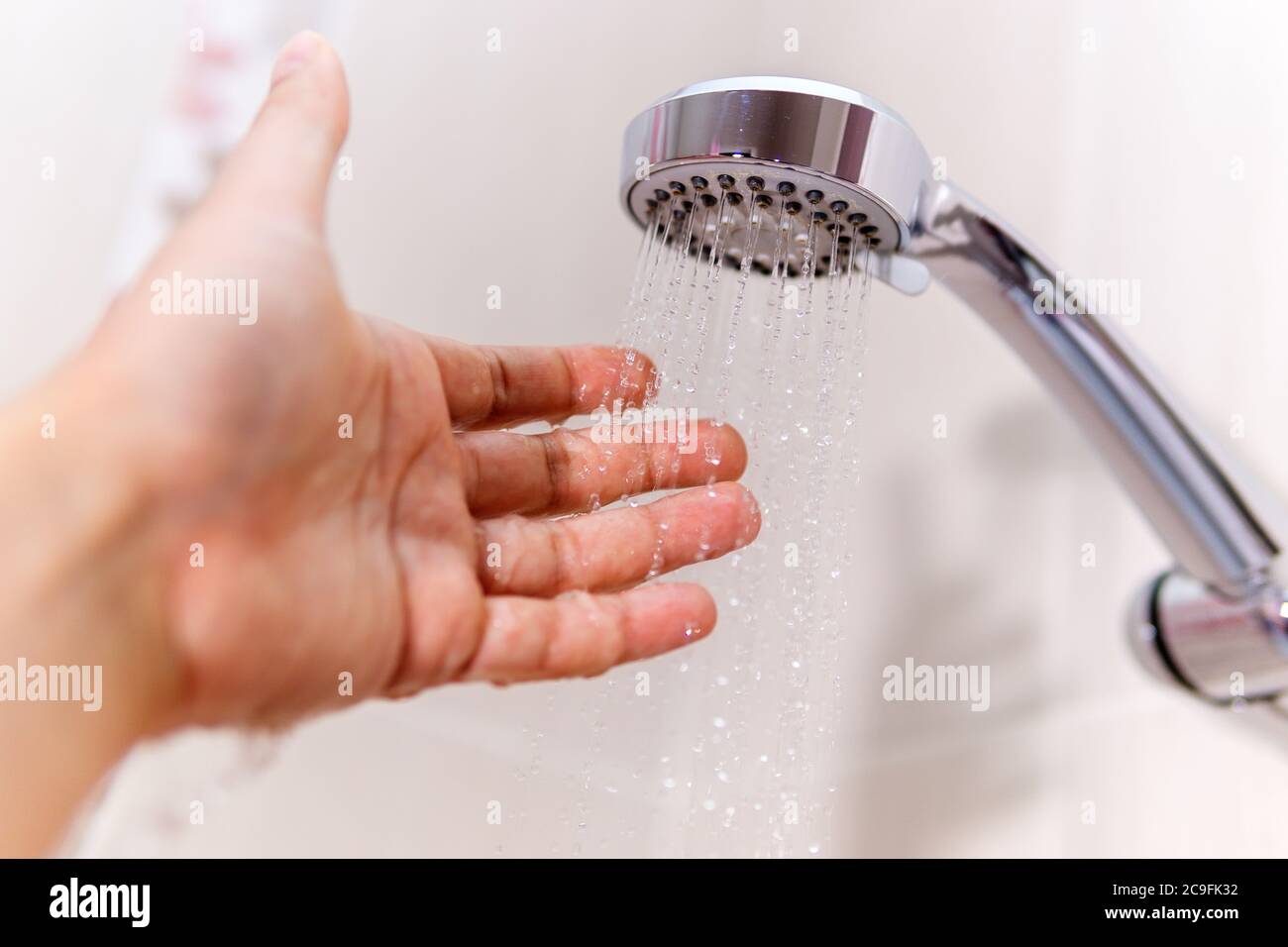 https://c8.alamy.com/comp/2C9FK32/check-the-temperature-of-the-shower-water-a-mans-hand-under-a-stream-of-water-selective-focus-2C9FK32.jpg