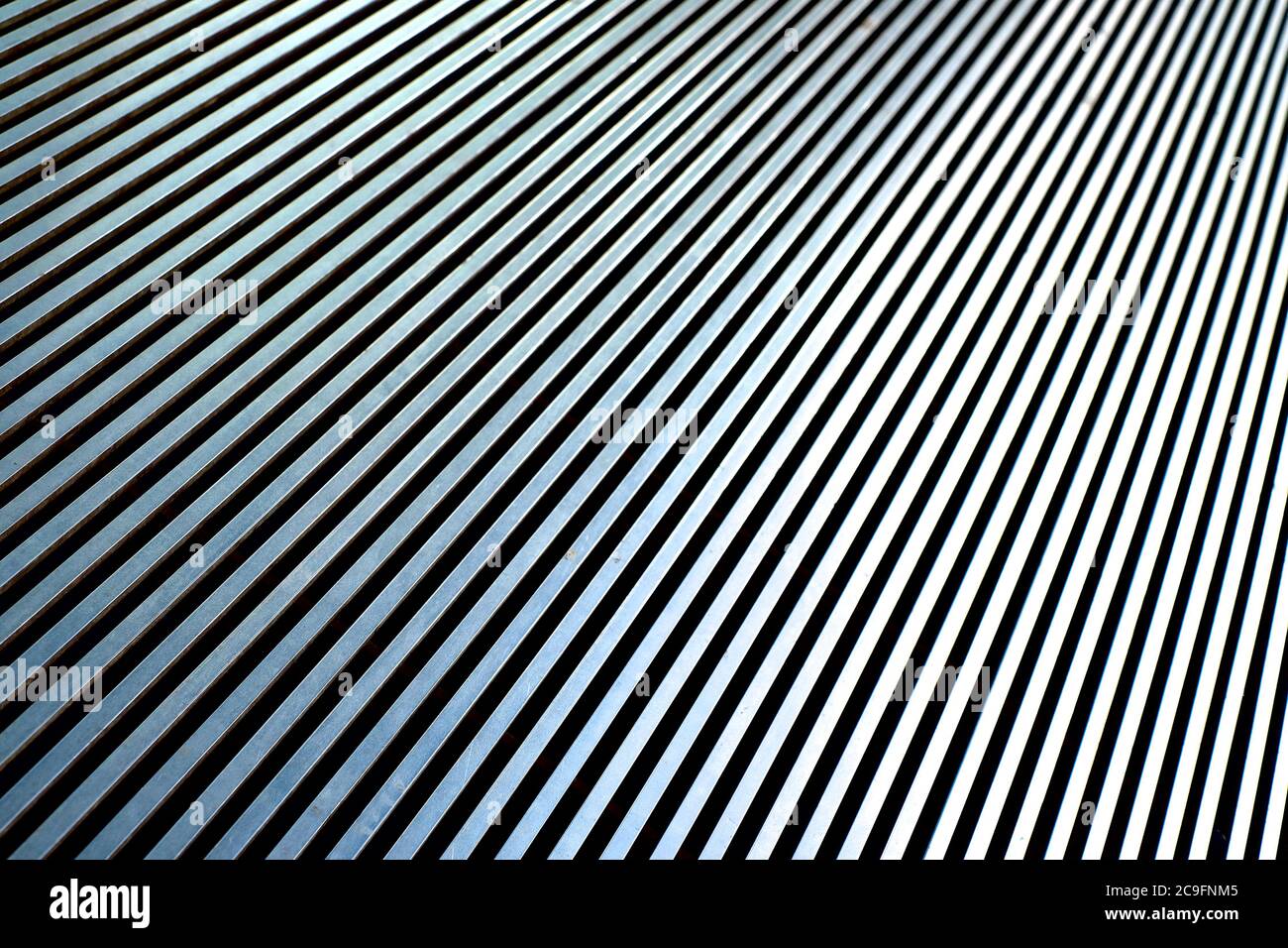 Diagonal converging silver lines on a steel surface. Stock Photo