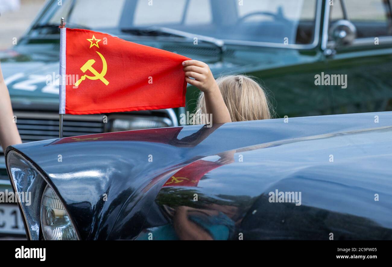 Beuster, Germany. 24th July, 2020. The flag of the Soviet Union is waving on a Soviet Chaika limousine which is on the blue light days in the blue light museum Beuster on the exhibition area. Despite corona protection measures, the blue light museum on the Elbe celebrates its museum week and shows the collection of historical fire brigade, police and military technology. Credit: Jens Büttner/dpa-Zentralbild/ZB/dpa/Alamy Live News Stock Photo