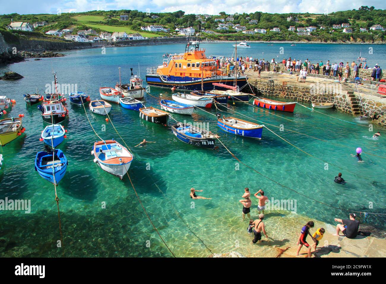 COVERACK, CORNWALL, UK - AUGUST 2013.  The picturesque harbour of Coverack in Cornwall full of holidaymakers during the RNLI Lifeboat celebration day Stock Photo