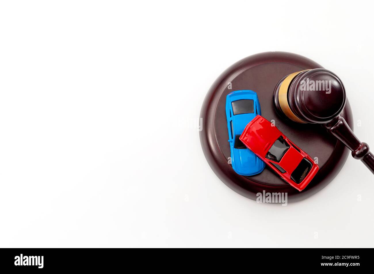 Insurance claim following a car accident settled in court and automobile safety legislation conceptual idea with judge gavel and model cars colliding Stock Photo