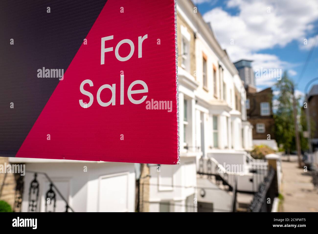 'FOR SALE' estate agency sign on street of houses Stock Photo Alamy