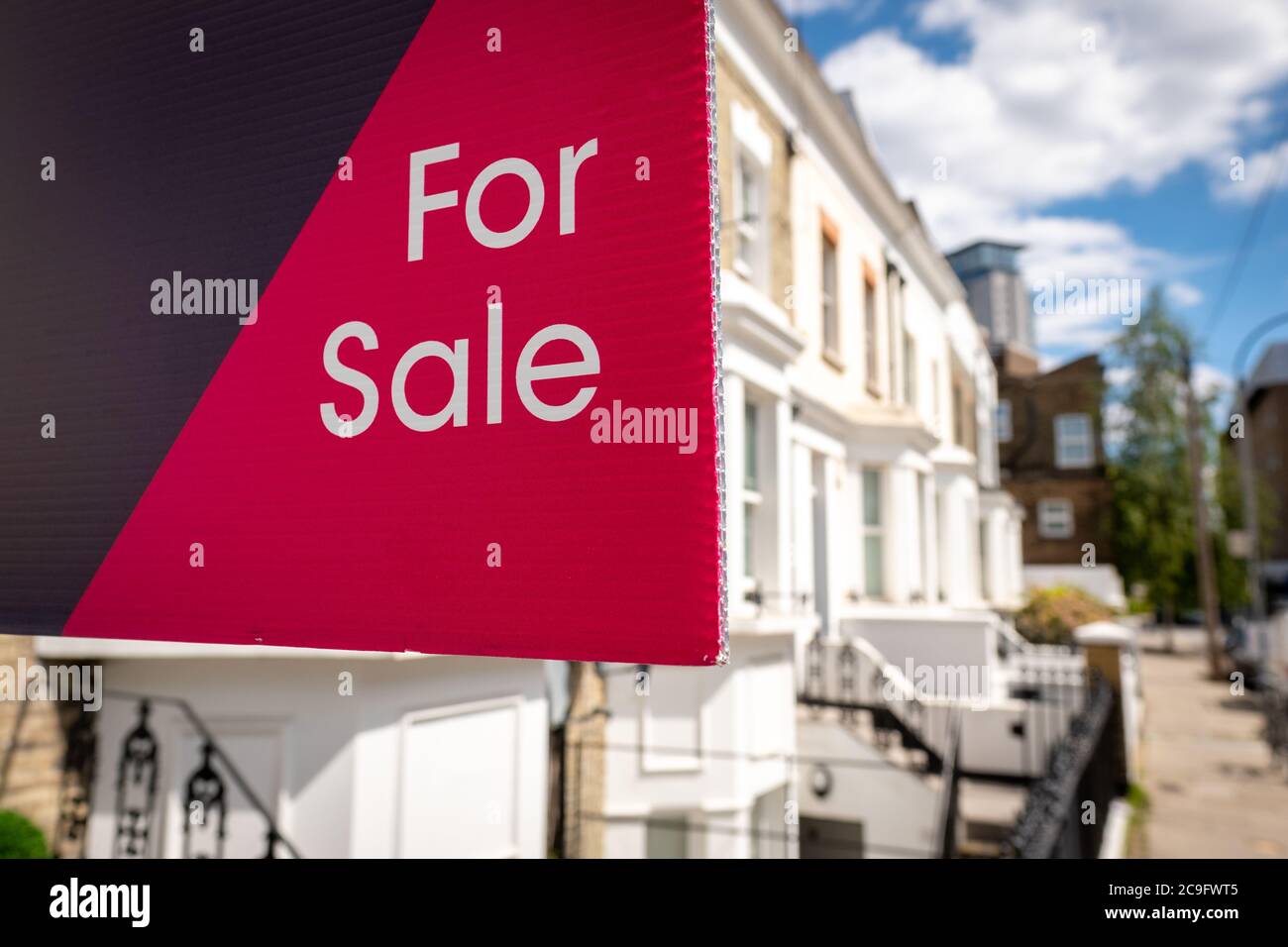 'FOR SALE' estate agency sign on street of houses Stock Photo - Alamy
