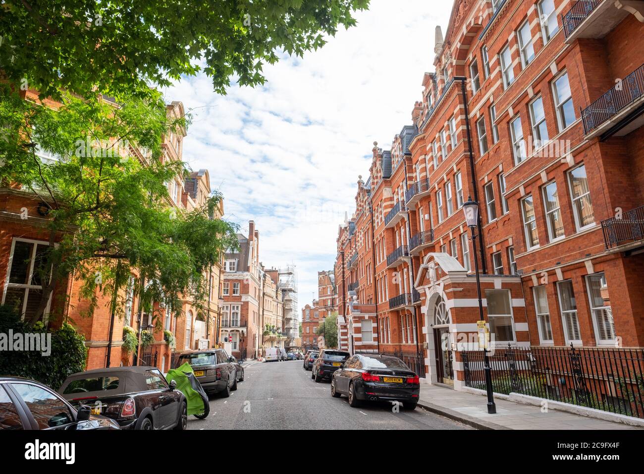 London, July, 2020: Residential street of beautiful red brick terraced London townhouses in Kensington Court, west London Stock Photo