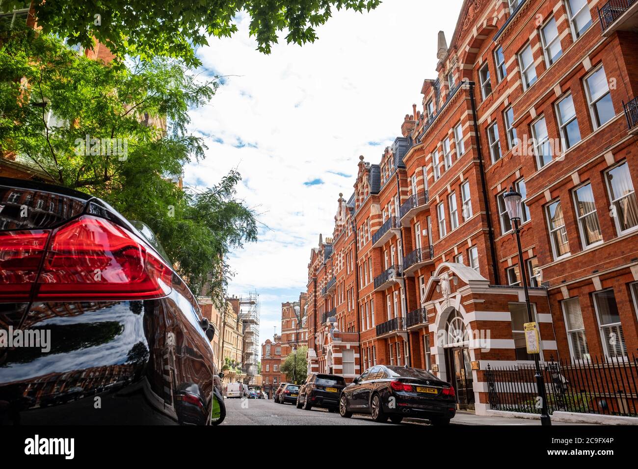 London, July, 2020: Residential street of beautiful red brick terraced London townhouses in Kensington Court, west London Stock Photo