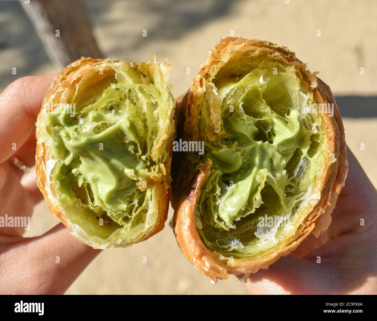 Closeup shot of two halves of a croissant with pistachio cream filling