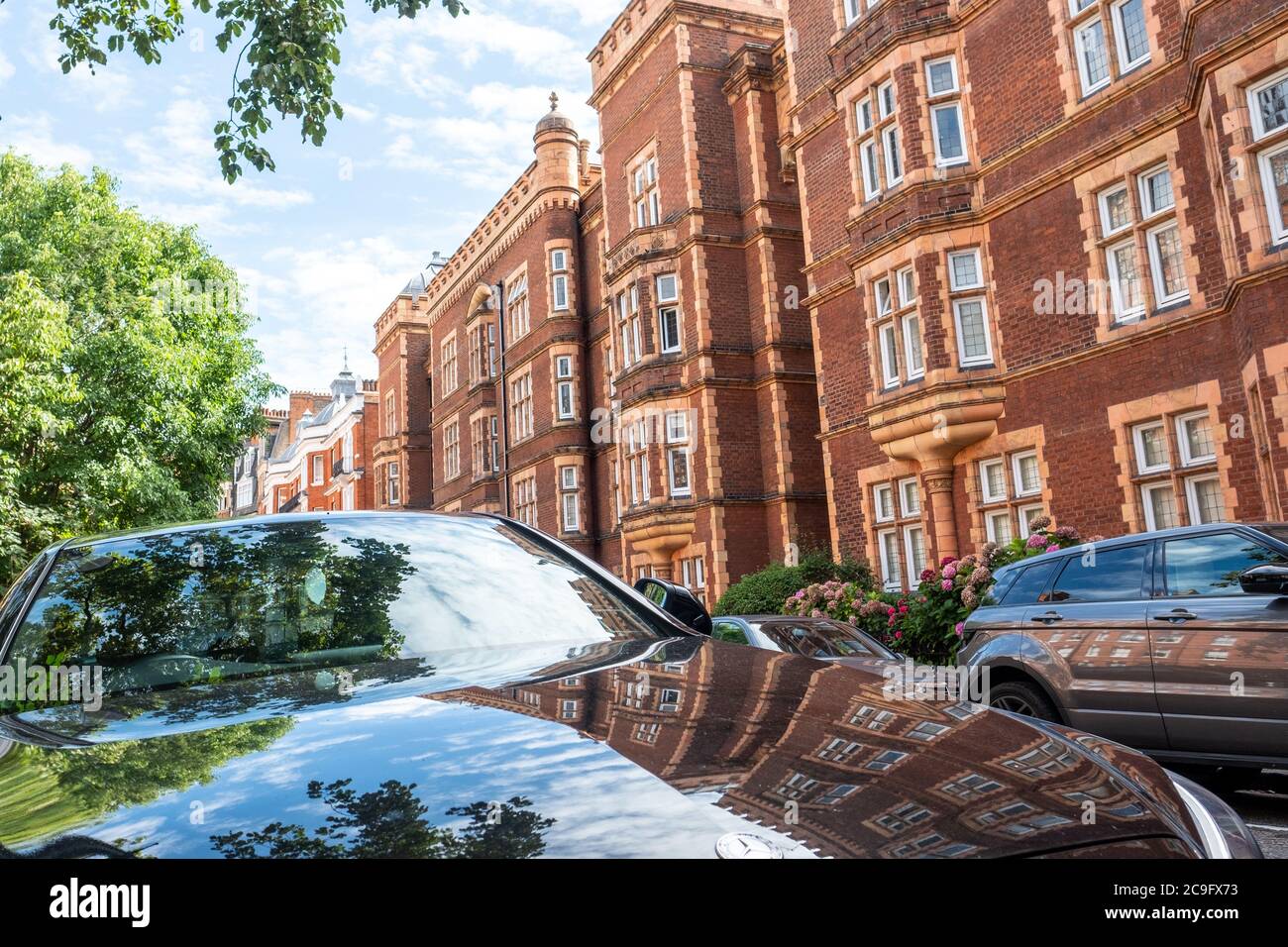 London, July, 2020: Residential street of beautiful red brick terraced London townhouses in Kensington Court, west London Stock Photo