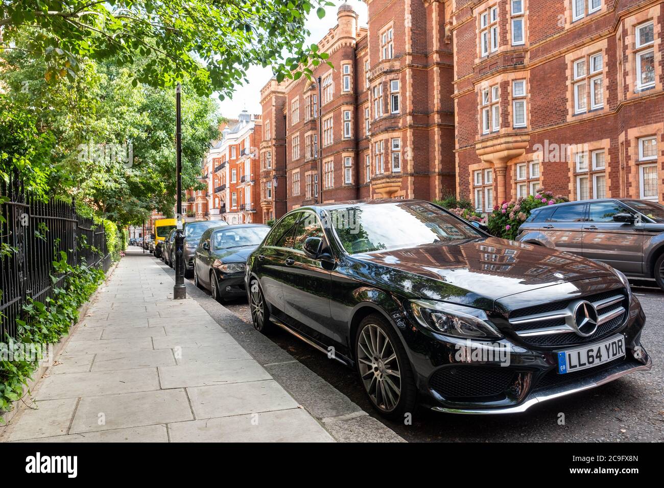 LONDON- JULY, 2020: Black Mercedes car  parked on beautiful street of Kensington townhouses Stock Photo