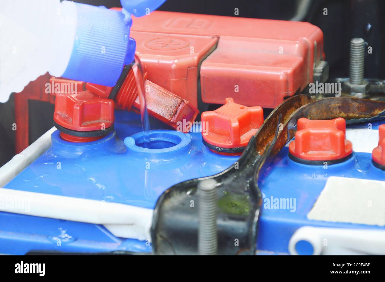 distilled water flowing from plastic bottle filling in car batteries