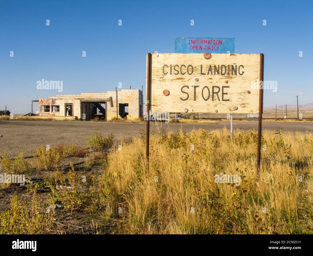 An old name board for the general store with a ruin in the background in the ghost town of Cisco