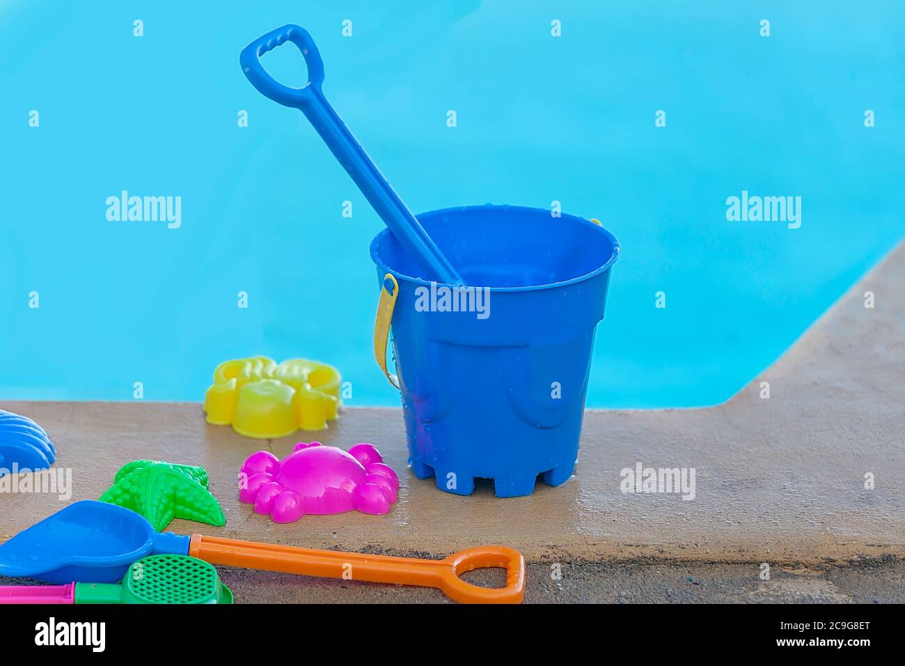 Bucket And Spade. Isolated. Colourful kids beach toys by the side of