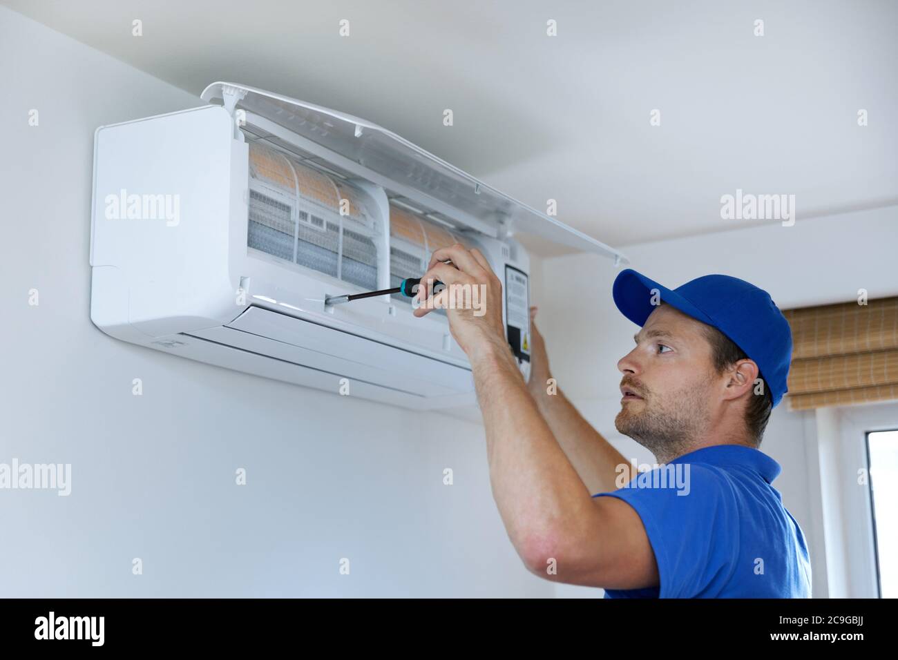 hvac services - technician installing air conditioner on the wall at home Stock Photo
