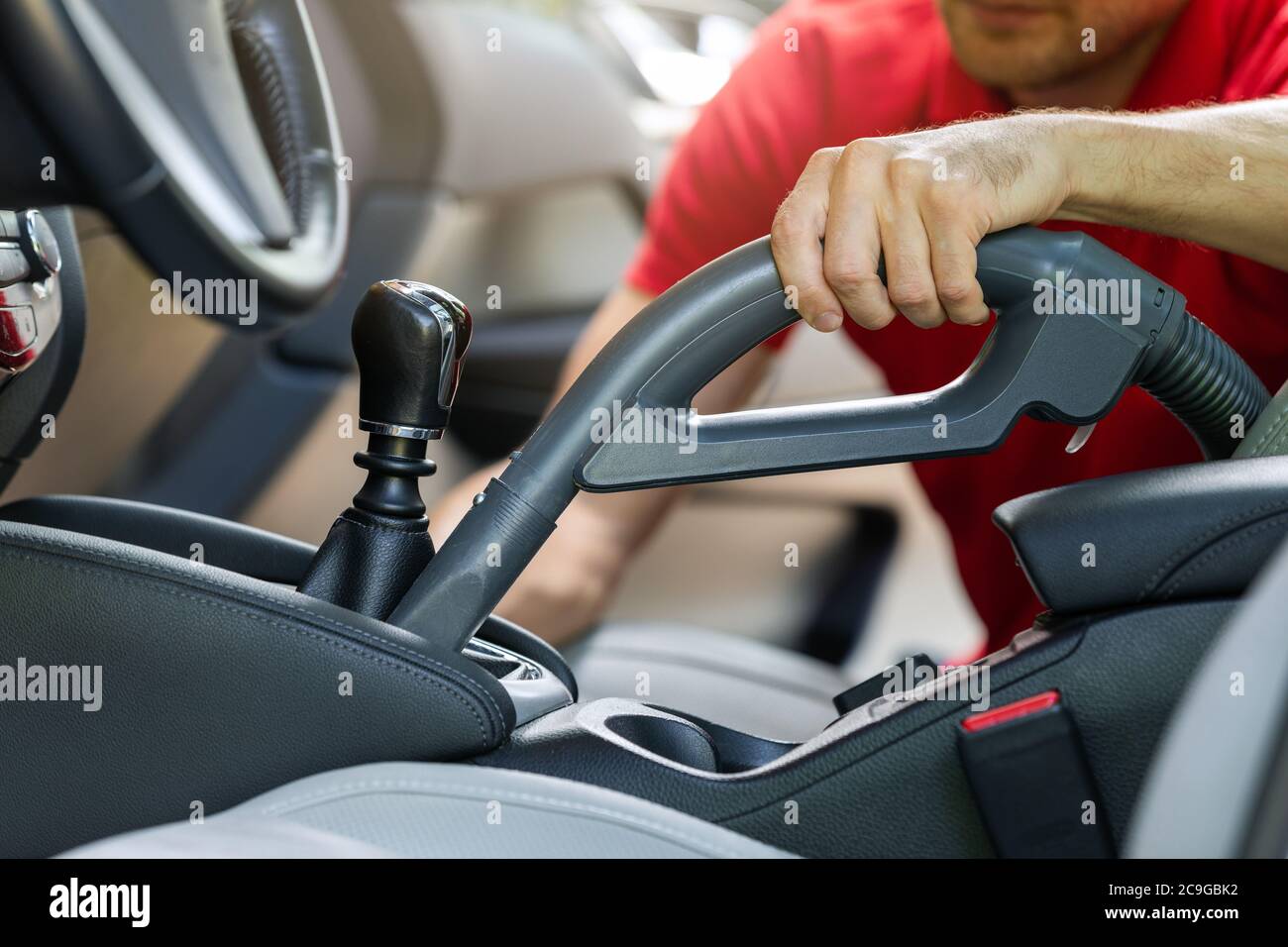 man cleaning car interior with vacuum cleaner Stock Photo