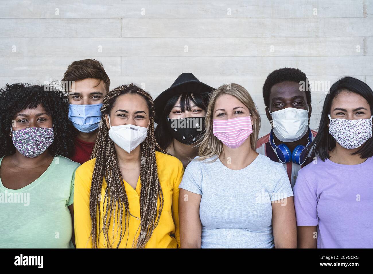 Group young people wearing face mask for preventing corona virus outbreak - Millennial friends with different age and culture portrait Stock Photo