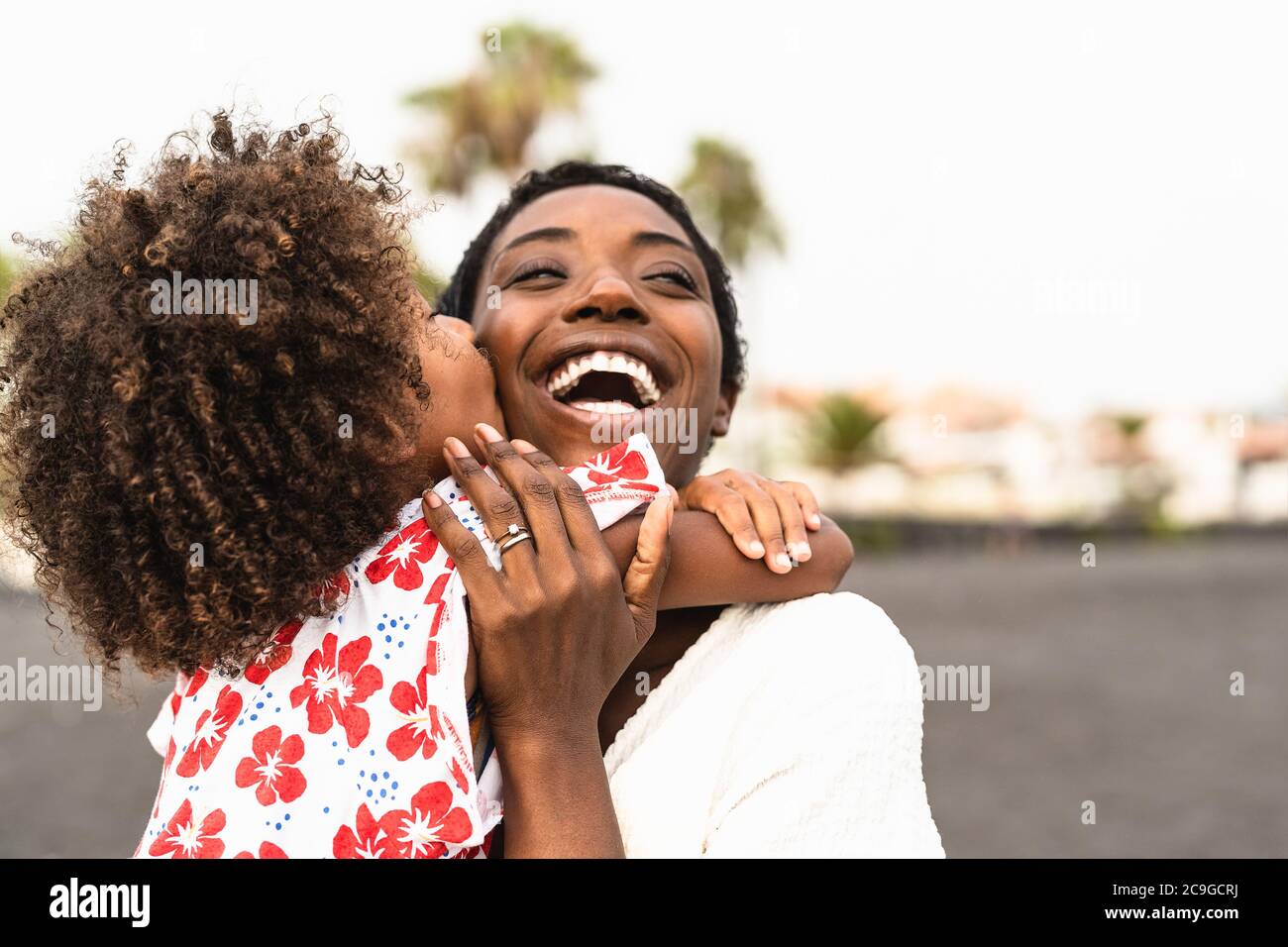 Happy African family on the beach during summer holidays - Afro American people having fun on vacation time Stock Photo