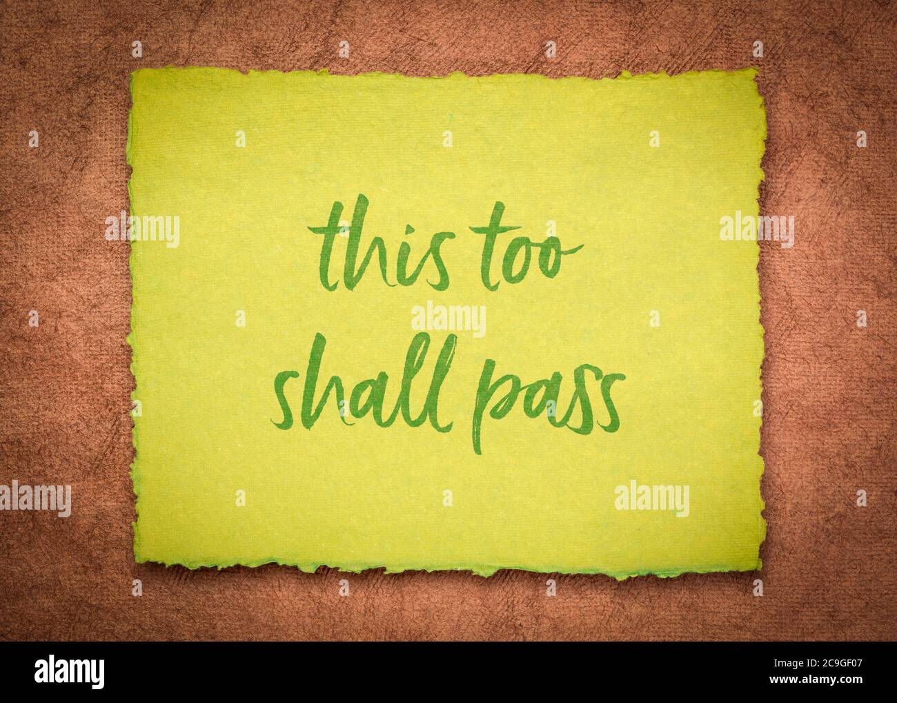 this too shall pass - inspirational handwriting on a handmade paper, positivity, hope, temporary nature, or ephemerality of the human condition and si Stock Photo