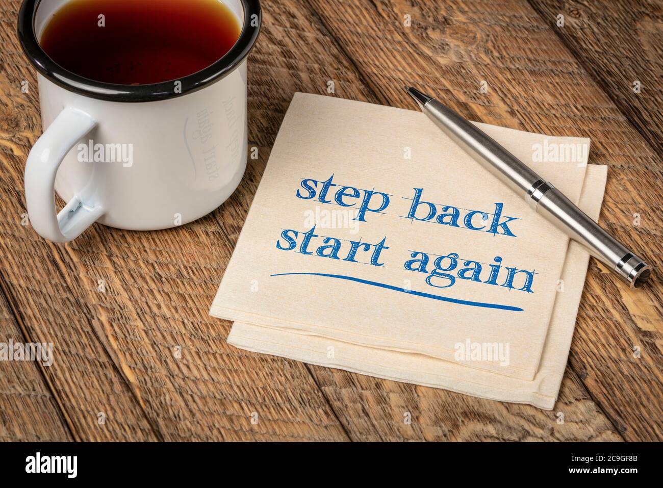 step back, start again motivational note - handwriting on a napkin with a cup of tea, persistence and determination concept Stock Photo