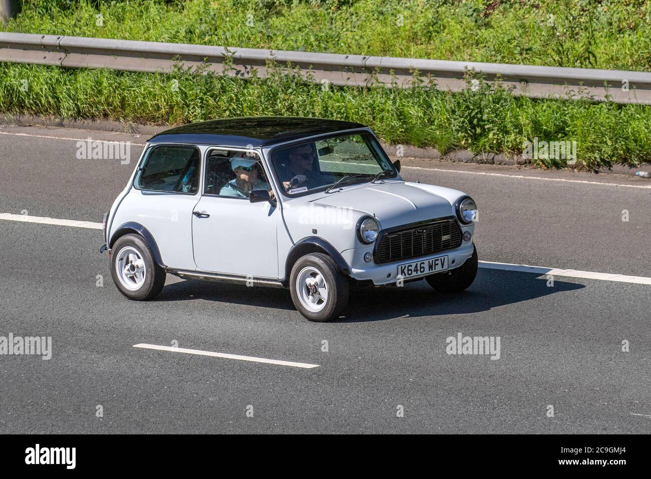 North West Classic Mini Owners club 1993 white Rover Mini Mayfair Auto; Vehicular traffic moving vehicles, cars driving vehicle on UK roads, motors, motoring on the M6 motorway highway network. Stock Photo