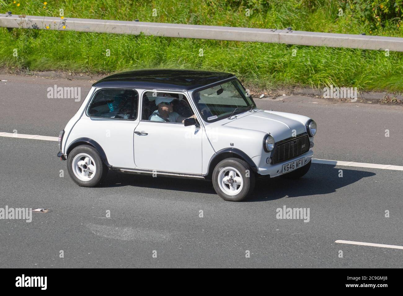 North West Classic Mini Owners club 1993 white Rover Mini Mayfair Auto; Vehicular traffic moving vehicles, cars driving vehicle on UK roads, motors, motoring on the M6 motorway highway network. Stock Photo