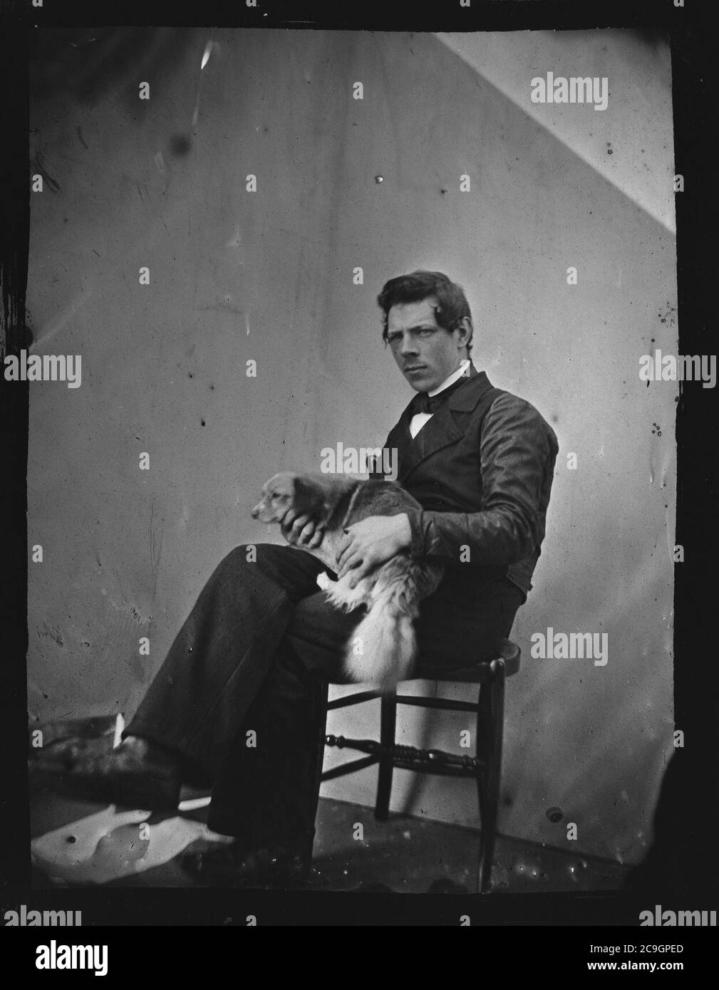 Jacob Olie Jbz (1834-1905) Zelfportret, schrijlings op stoel, met hondje op schoot (max res). Stock Photo