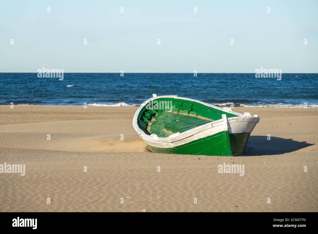 Wrecked wooden fisher boat. boat stranded in the sand of a beach Broken abandoned boat in sand, sea coast line Stock Photo