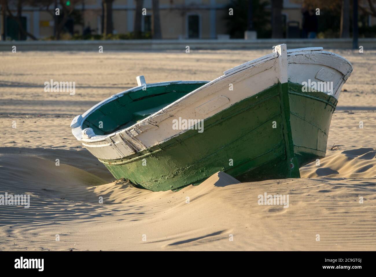 Wrecked wooden fisher boat. boat stranded in the sand of a beach Broken abandoned boat in sand Stock Photo