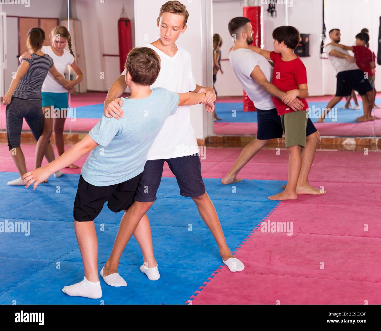 Kids with adults practicing effective techniques of selfdefence in