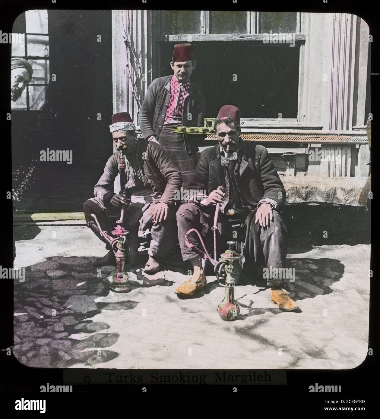 Hookah smokers in Izmir / Smyrna, Turkey. Hand-colored photograph on dry glass plate from the Herry W. Schaefer collection, around 1910. Stock Photo