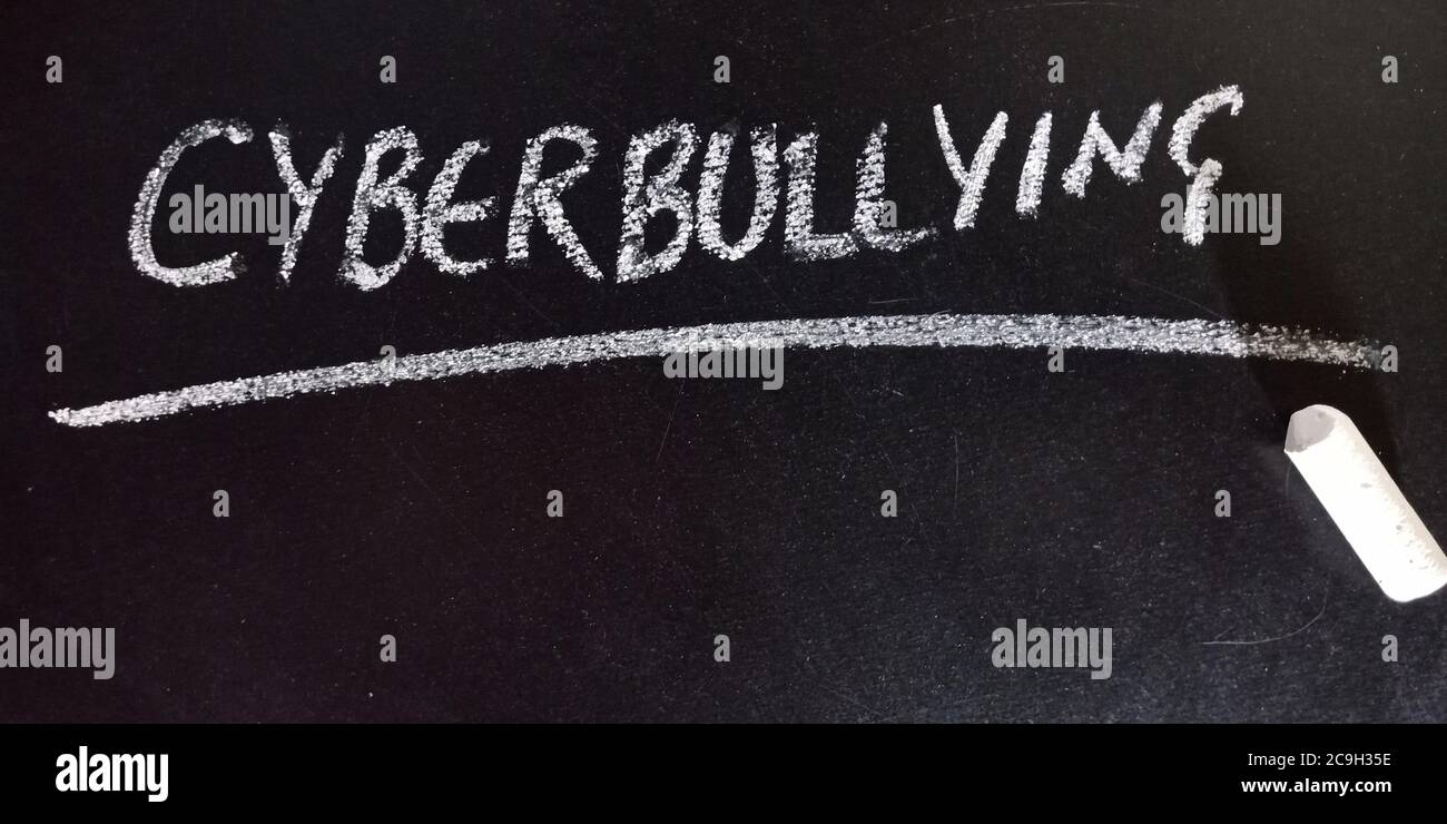 Cyberbullying word presented on chalkboard with school educational chalkboard concept background for learning purpose. Stock Photo