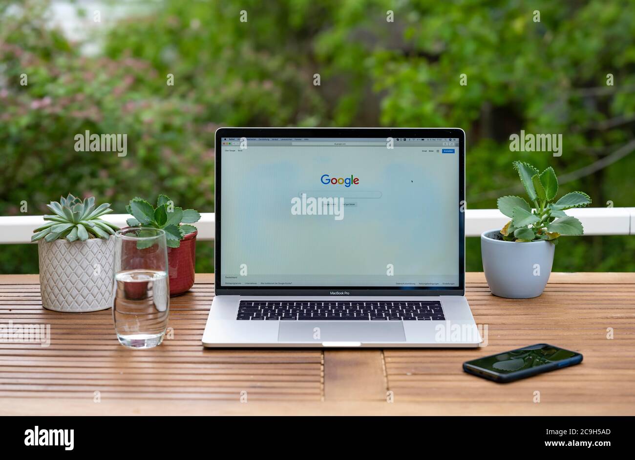 Home office with laptop, Apple MacBook Pro with iPhone X at the desk, with website Google, Germany Stock Photo